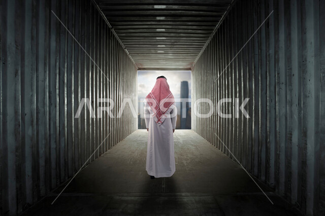 زاوية من الخلف لرجل عربي خليجي سعودي يقف في نهاية الممر ، يتطلع لتحقيق رؤية مستقبلية أفضل ، مواكبة التطلعات و مواجهة التحديات ، تحقيق الطموحات ، رؤية 2030