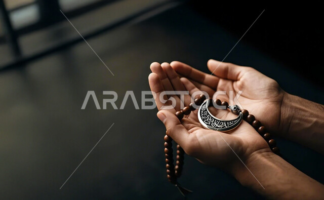 Striving in worship and preserving remembrance, a close-up of the hands of a Saudi Arabian Gulf man holding a rosary, raising his hands and supplicating to God, gestures indicating supplication and entreaty, obedience and drawing closer to God in the holy month of Ramadan