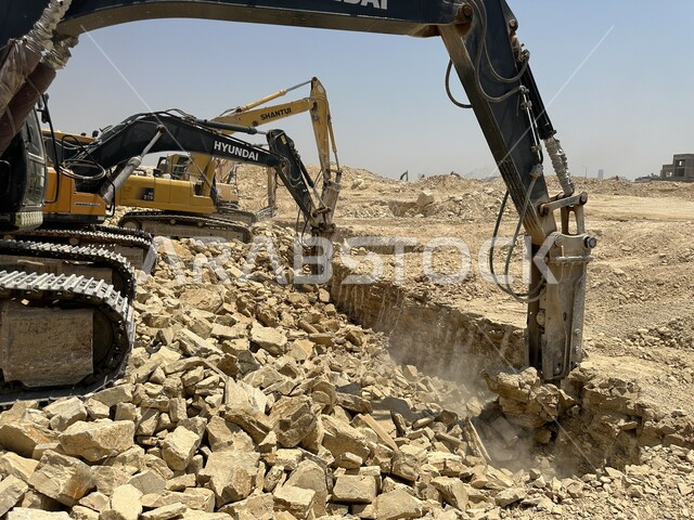 مهنة ووظيفة هندسية صناعية في السعودية، الاعتماد على الآلات والمعدات الثقيلة في أعمال البناء، جرافات ضخمة تعمل في الحفر ورفع الأنقاض والأتربة في موقع العمل، مفهوم الهندسة المعمارية والإنشاءات، تحسين البنية التحتية لإقامة المباني والمشاريع الحديثة في مدينة الرياض