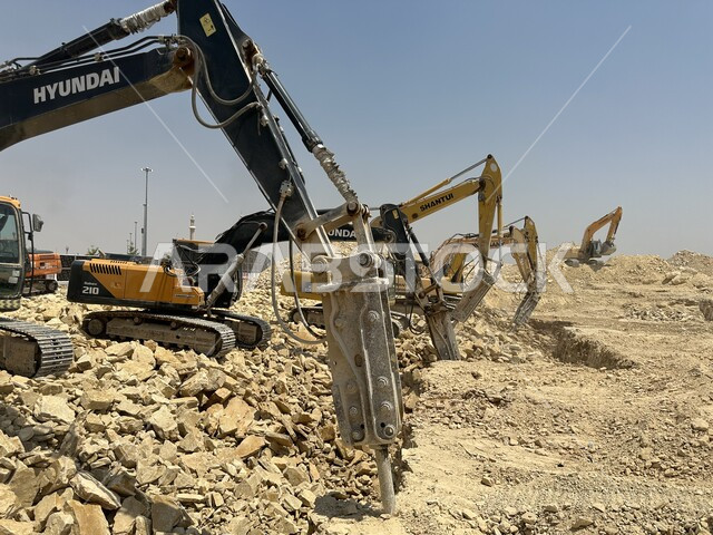 الاعتماد على الآلات والمعدات الثقيلة في أعمال البناء، مهنة ووظيفة هندسية صناعية في السعودية، جرافات ضخمة تعمل في الحفر ورفع الأنقاض والأتربة في موقع العمل، مفهوم الهندسة المعمارية والإنشاءات، تحسين البنية التحتية لإقامة المباني والمشاريع الحديثة في مدينة الرياض