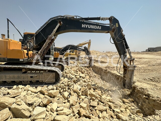 وظيفة ومهنة هندسية صناعية في السعودية، تحسين البنية التحتية لإقامة المباني والمشاريع الحديثة في مدينة الرياض، مفهوم الهندسة المعمارية والإنشاءات، جرافات ضخمة تعمل في الحفر ورفع الأنقاض والأتربة في موقع العمل، الاعتماد على الآلات والمعدات الثقيلة في أعمال البناء