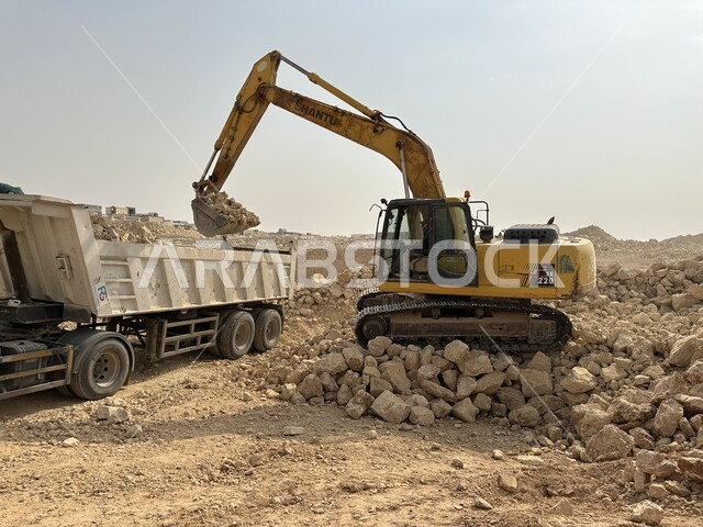 جرافات ضخمة تعمل في الحفر ورفع الأنقاض والأتربة في موقع العمل، الاعتماد على الآلات والمعدات الثقيلة في أعمال البناء، وظيفة ومهنة هندسية صناعية في السعودية، تحسين البنية التحتية لإقامة المباني والمشاريع الحديثة في مدينة الرياض، مفهوم الهندسة المعمارية والإنشاءات