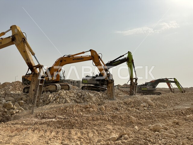 جرافات ضخمة تعمل في الحفر ورفع الأنقاض والأتربة في موقع العمل، وظيفة ومهنة هندسية صناعية في السعودية، تحسين البنية التحتية لإقامة المباني والمشاريع الحديثة في مدينة الرياض، مفهوم الهندسة المعمارية والإنشاء، الاعتماد على الآلات والمعدات الثقيلة في أعمال البناء