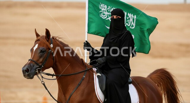Pride and pride in national identity, passion for raising and caring for horses, Saudi National Day September 23, a veiled Saudi Gulf Arab woman wearing a black abaya carrying the Kingdom's flag riding an Arabian horse on soft sand, Flag Day March 11
