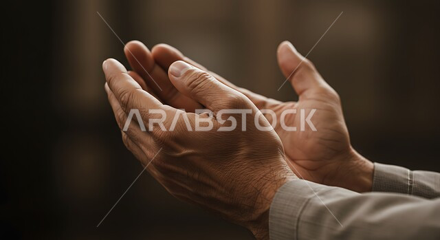 الإجتهاد في العبادة والحفاظ على الذكر، صورة مقربة لإيدي رجل عربي سعودي خليجي يرفع يديه ويدعو الله، إيماءات يدين تدل على التوسل والتضرع, الطاعة والتقرب الى الله في شهر رمضان المبارك