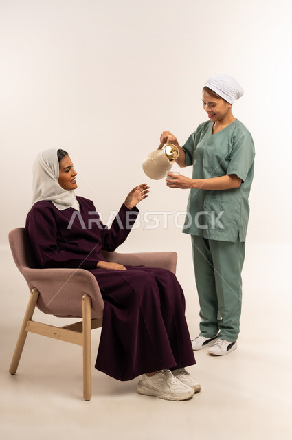 أداء الأعمال المنزلية الروتينية على أكمل وجه، بورتريه لسيدة عربية خليجية سعودية محجبة ترتدي عباءة خمرية تجلس على الأريكة وتأخد كوب القهوة من الخادمة، حسن الضيافة والاستقبال، الاستعانة بمساعدة عاملة فلبينية في المنزل، استئجار العماله المنزليه المرخصه والمؤهله، خلفية بيضاء