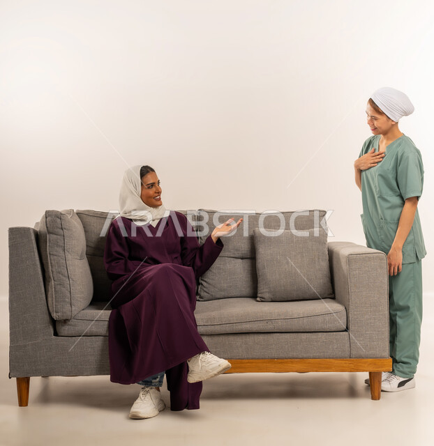 الإحسان في التعامل مع الخادمات في البيوت، توفير خدمات العناية بالمنزل، استقدام العماله المنزليه المرخصه والمؤهله، بورتريه لامرأة عربية خليجية سعودية محجبة ترتدي عباءة خمية تجلس على اريكة تتحدث مع العاملة الفلبينية، مدبرة منزل تستعين بخادمة أجنبية، خلفية بيضاء