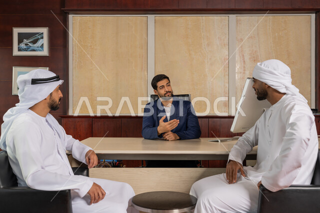مهنة ووظيفة اماراتية, النقاش في مهام العمل, مكاتب و شركات خليجية، الوحدة و التعاون الجماعي لتطوير العمل وحل المشكلات، مجموعه من رجال الاعمال العربيين الخليجيين الاماراتيين يجلسون في المكتب, تحقيق اهداف الشركة