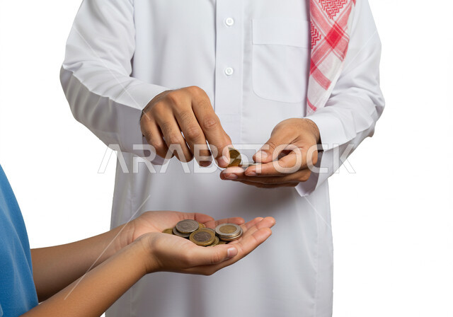  تقديم الاموال و العيدية، مفهوم التكافل الاجتماعي ومساعدة المحتاجين، العبادة والتقرب الى الله، بورتريه مقرب ليد رجل عربي خليجي سعودي يرتدي الشماغ والثوب التقليدي يقوم باعطاء النقود المعدنية لولد، اخراج زكاة الفطر للمحتاجين، الصدقة في شهر رمضان، خلفية بيضاء