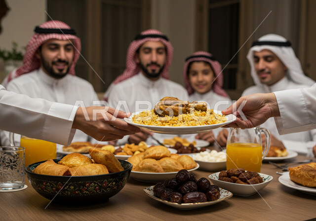 إكرام الوالدين ومشاركة الاطعمة، أجواء دينية رمضانية، صورة مقربة ليد إمراة عربية خليجية سعودية تقوم بوضع الطبق الرئيسي، سفرة افطار مليئة باصناف من المأكولات الشهية في شهر رمضان، اجتماع الأسرة حول مائدة الطعام، أداء فريضة الصيام، إيماءات السعادة و السرور