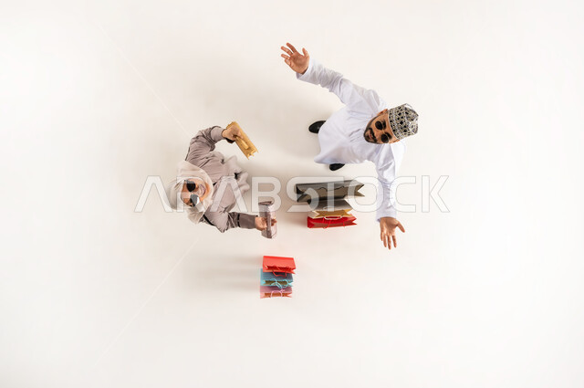 النظر الى الكاميرا بتعابير الحيرة في الاختيار، قضاء وقت ممتع بالتسوق، بورتريه علوي عامودي لشاب عربي خليجي عماني يرتدي الدشداشة والكمه والنظارة الشمسية يرفع يديه للاعلى بإيماءات الجهل وعدم المعرفة، سيدة محجبة تمسك بيدها حقائب، خلفية بيضاء