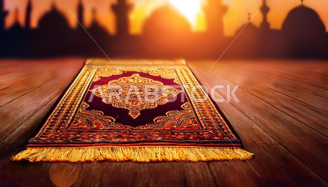 الاجتهاد في العبادة والتقرب إلى الله تعالى في شهر رمضان المبارك، سجادة صلاة على ارضية خشبية، خلفية مسجد اسلامي وقت غروب الشمس