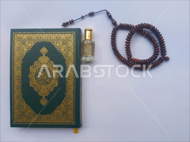 مفهوم التطيب والتعطر، الاجتهاد في الدعاء وطلب المغفرة, الاكثار من الاذكار في شهر رمضان المبارك، التعبد بتلاوة القران وحفظ وتفسير كلامه، صورة مقربة للمصحف الشريف مع سبحة وعطر، الجو الديني الروحاني, العبادة والتقرب إلى رب العالمين، خلفية بيضاء