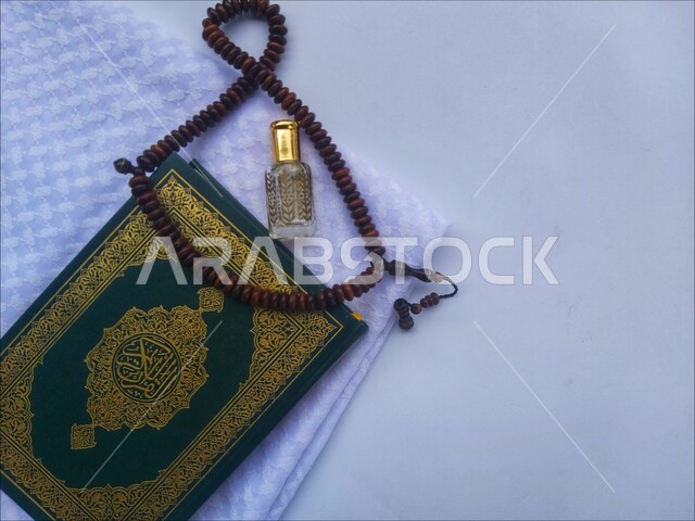 الاجتهاد في الدعاء وطلب المغفرة, الاكثار من الاذكار في شهر رمضان المبارك، التعبد بتلاوة القران وحفظ وتفسير كلامه، صورة مقربة للمصحف الشريف مع سبحة وعطر، الجو الديني الروحاني, العبادة والتقرب إلى رب العالمين، مفهوم التطيب والتعطر، خلفية بيضاء