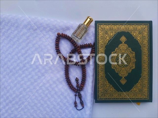 الاجتهاد في الدعاء وطلب المغفرة, الاكثار من الاذكار في شهر رمضان المبارك، التعبد بتلاوة القران وحفظ وتفسير كلامه، صورة مقربة للمصحف الشريف مع سبحة وعطر، الجو الديني الروحاني, العبادة والتقرب إلى رب العالمين، مفهوم التطيب والتعطر، خلفية بيضاء