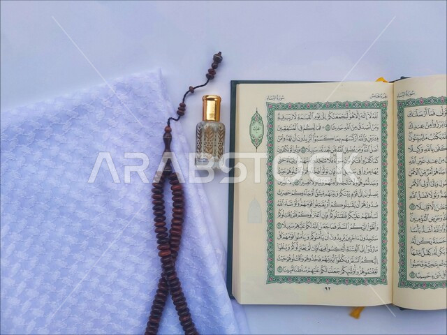 التعبد بتلاوة القران وحفظ وتفسير كلامه، الاجتهاد في الدعاء وطلب المغفرة, الاكثار من الاذكار في شهر رمضان المبارك، صورة مقربة للمصحف الشريف مع سبحة وعطر، الجو الديني الروحاني, العبادة والتقرب إلى رب العالمين، مفهوم التطيب والتعطر، خلفية بيضاء