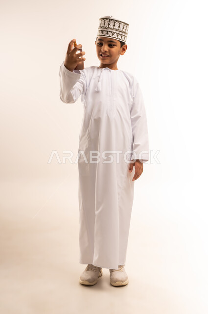 التطيب والتعطر بالعود والزيوت العطرية, التسويق لمنتجات العطور والمستحضرات النسائية, مفهوم الأناقة والاهتمام بالمظهر الخارجي, بورتريه مقرب من الجانب لسيدة عربيه سعودية خليجية محجبة مبتسمة تقوم برش العطر بإيماءات الإعجاب بالروائح العطرة, خلفية ملونة