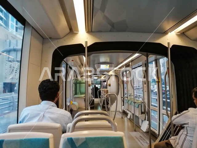صورة من الخلف لركاب داخل مترو دبي السريع ، جمال التصميم من الداخل ، وسائل نقل و مواصلات حديثة في مدينة دبي في الإمارات العربية المتحدة