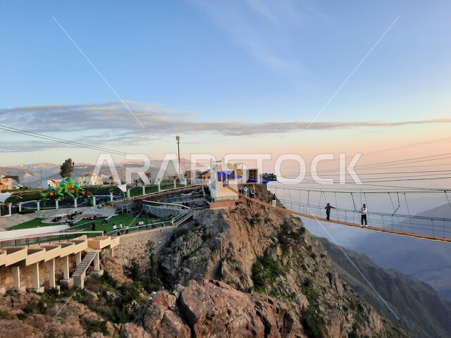 التشكيل والتكوين الصخري للجبل في المملكة العربية السعودية، منظر طبيعي متميز للقمة والمرتفع الجبلي، المنتزهات والحدائق العامة، فعالية السير على الجسر الخشبي المعلق في حديقة الأمير حسام في محافظة الباحة، معلم سياحي مشهور، مكان جذب واستقطاب السائحين