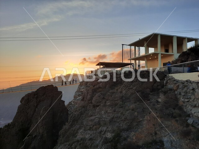 التشكيل والتكوين الصخري للجبل في المملكة العربية السعودية، منظر طبيعي متميز للقمة والمرتفع الجبلي وقت الغروب، المنتزهات والحدائق العامة، الجسر الخشبي المعلق في حديقة الأمير حسام في محافظة الباحة، معلم سياحي مشهور، مكان جذب واستقطاب السائحين