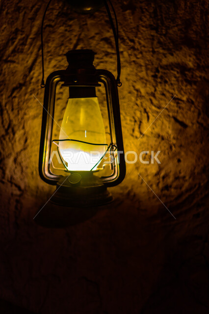 مصباح زيتي قديم معلق على حائط من الطين , شعبيات أثرية .