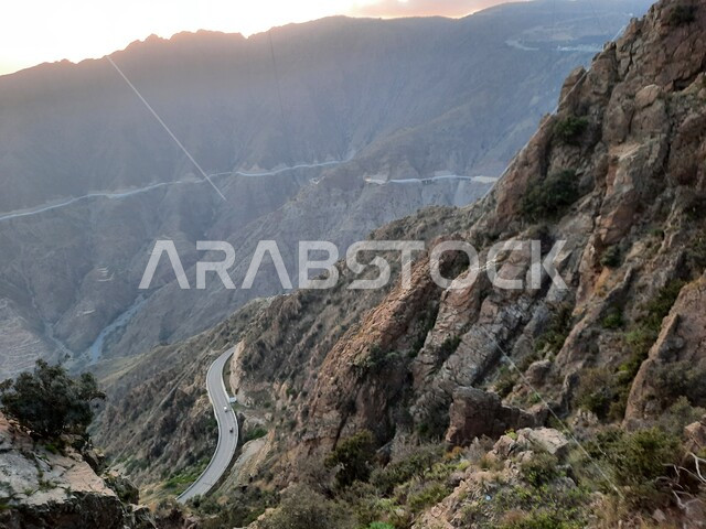 The winding and rugged road on the mountain in Al Baha Governorate, the terrain, formation and rock formation of the summit and the mountain height, a distinctive natural landscape, Prince Hussam Park in the Kingdom of Saudi Arabia, a place of attraction and attraction for tourists