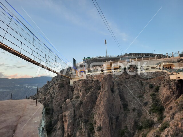 منظر طبيعي متميز للقمة والمرتفع الجبلي، التشكيل والتكوين الصخري للجبل في المملكة العربية السعودية، الجسر الخشبي المعلق في حديقة الأمير حسام في محافظة الباحة، المنتزهات والحدائق العامة، معلم سياحي مشهور، مكان جذب واستقطاب السائحين