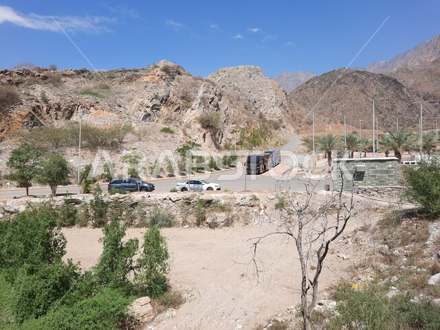 التكوين والتشكيل الصخري للمرتفع الجبلي، صورة من الاعلى لحركة المرور في الطرق والشوارع العامة في قرية ذي عين الأثرية في منطقة الباحة, معلم سياحي مشهور في المملكة العربية السعودية, منظر طبيعي متميز للجبال