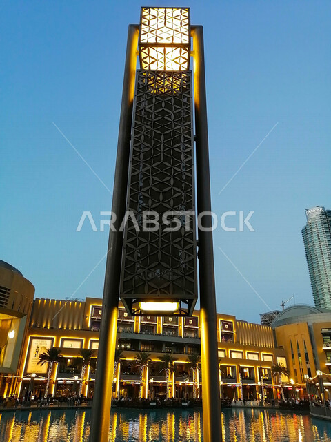صورة جمالية مقربة لعمود إنارة وقت الغرب في محيط مول دبي ، روعة و جمال الزخارف و التصاميم المشكلة عليه ، معالم و مناطق سياحية في إمارة دبي في الإمارات العربية المتحدة