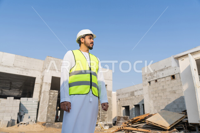 وظيفة ومهنة هندسية شبابية، مهندس عربي خليجي اماراتي يرتدي الكندورة والسترة وخوذة الحماية يعمل في القطاع الهندسي في الامارات العربية المتحدة، الاشرف على عمليات البناء، مفهوم ادارة المشاريع الهندسية والانشاءات، دراسة المخطط والمشروع على ارض الواقع