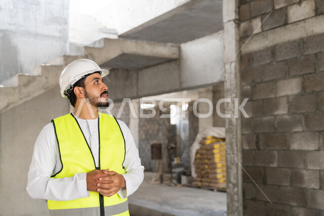 Construction Supervisor, Engineering Project Management Concept, Study of Plan and Project on the Ground, Youth Engineering Profession and Job, Arab Gulf Emirati Engineer Wearing Kandora, Jacket and Protective Helmet Working in the Engineering Sector in the United Arab Emirates