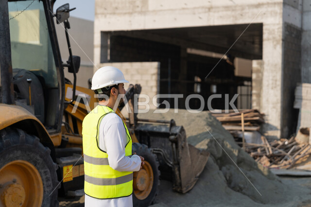 Construction Supervisor, Engineering Project Management Concept, Study of Plan and Project on the Ground, Youth Engineering Profession and Job, Arab Gulf Emirati Engineer Wearing Kandora, Jacket and Protective Helmet Working in the Engineering Sector in the United Arab Emirates