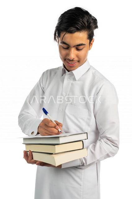 بورتريه لطالب جامعي عربي خليجي سعودي يحمل بيد مجموعة من الكتب  ، مستمتع بقراءة الكتاب الجامعي ،تدوين الملاحظات ، حل الواجبات ،المذاكرة للاختبارات الجامعية ، مراجعة الدروس اليومية ، التعليم الجامعي في المملكة العربية السعودية