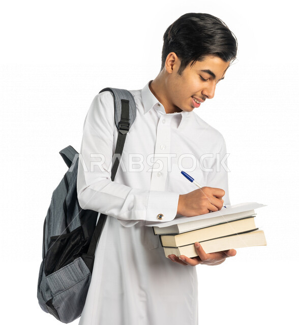 بورتريه لطالب جامعي عربي خليجي سعودي يحمل الحقيبة الجامعية و بيد مجموعة من الكتب ،تدوين الملاحظات ، قراءة الكتب ، حل الواجبات الجامعية  ،المذاكرة للاختبارات الجامعية ، مراجعة الدروس اليومية ، التعليم الجامعي في المملكة العربية السعودية