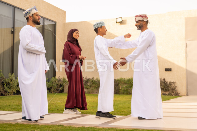 عناق الأبناء الدافئ  ، ايماءات الاشتياق والحب، ولد عربي خليجي عماني يتلهف ليعانق والده  ، أنشطة ترفيهية عائلية ، قضاء الأوقات السعيدة في إحدى الشاليهات في سلطنة عمان ، المودة والألفة بين افراد الاسرة .