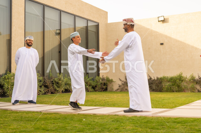 ايماءات  الاشتياق و الحب, مشاعر الأبوة و العطف، ولد عربي خليجي عماني يركض بتلهف ليعانق والده, عناق الأبناء الدافئ ، مفهوم الأسرة السعيدة ، قضاء أوقات عائلية ممتعة مع الأبناء في الحديقة.