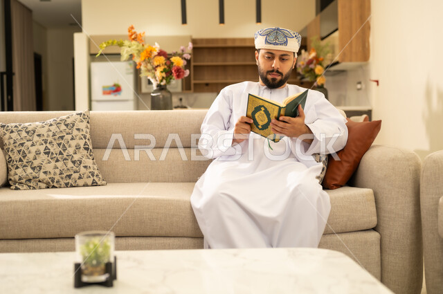 تلاوة وقراءة القرآن الكريم وتدبر معانيه، رجل عربي خليجي عماني يرتدي الدشداشة والعمامة  يحمل بيده المصحف الشريف، الإكثار من ذكر الله تعالى ، إسلاميات وعبادة ،التقرب الى الله ، الاجتهاد في العبادة .