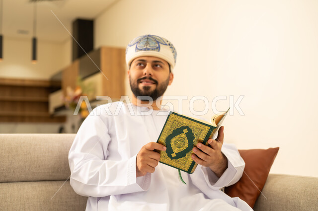 الاجتهاد في العبادة، تلاوة وقراءة القرآن الكريم وتدبر معانيه، رجل عربي خليجي عماني يرتدي الدشداشة والعمامة يحمل بيده المصحف الشريف وينظر الى شئ ما ، الإكثار من ذكر الله تعالى، التقرب الى الله ، الشعور بالخشوع والطمأنينة .