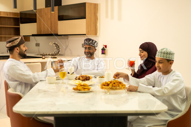ديكورات و زينة رمضانية ، تبادل الأحاديث بين أفراد الأسرة ، العزائم والولائم في الأعياد والمناسبات الاسلامية ، عائلة عربية خليجية عمانية تجتمع على مائدة الافطار فى شهر رمضان ، الاحتفال بقدوم الشهر الكريم ،المأكولات والمقبلات الشهية ، شهر الخير والبركة .