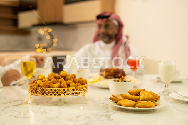 سفرة مليئة بالمأكولات والمقبلات العربية الشهية ، كسر الصيام عند سماع اذان المغرب ، الاحتفال بقدوم شهر رمضان المبارك ، سفرة مليئة بأصناف من المأكولات والمقبلات العربية السعودية، عائلة عربية خليجية سعودية تجتمع على مائدة الافطار فى شهر رمضان ، مناسبات دينية اسلامية .