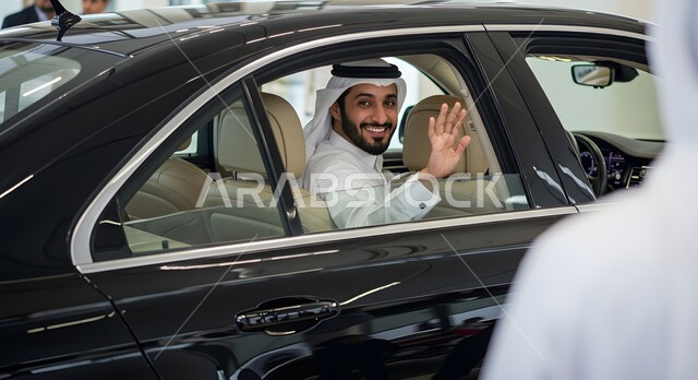 وسائل النقل والمواصلات الحديثة، التنقل باستخدام السيارة الخاصة، رجل عربي خليجي سعودي مبتسم يرتدي الغترة والثوب التقليدي يجلس داخل سيارته، رفع كف اليد بتعابير القاء التحية والسلام، ايماءات السعادة والسرور