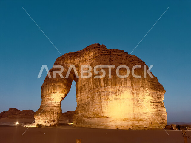 صخرة الفيل المضيئة في محافظة العلا في الليل، مكان سياحي طبيعي مشهور، التضاريس في القمم والمرتفعات الجبلية، الاستمتاع في صحاري المملكة, معلم اثري تاريخي قديم، الجبال والتكوينات الصخرية في المناطق الصحراوية