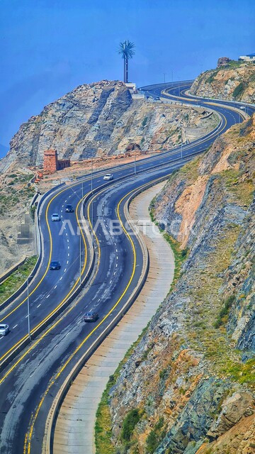 طريق إسفلتي ملتوي وعر وسط الجبال الصخرية، الطبيعة والبيئة الجبلية القاسية في مدينة الطائف، القمم والمرتفعات في المملكة العربية السعودية، حركة مرور السيارات في طريق عقبة الهدا، الطرق والشوارع المعبدة السريعة بين مكة والطايف, الاهتمام بتهيئة البنية التحتية