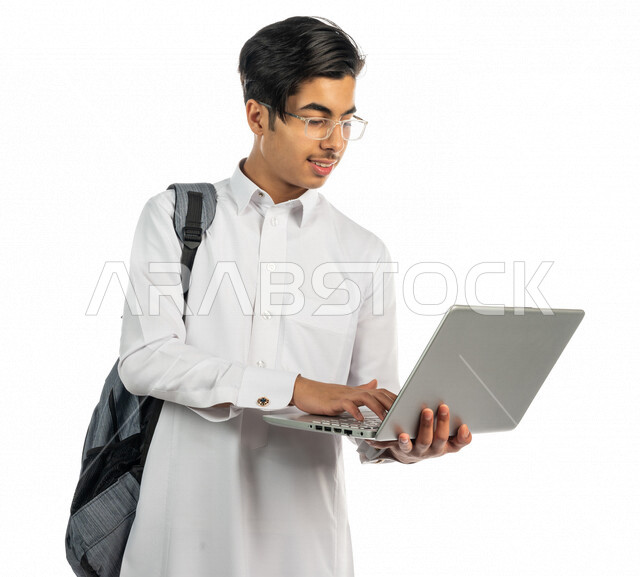 Portrait of a Saudi Arabian Gulf university student holding a laptop in ...