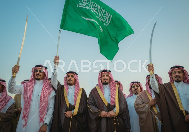 يوم العلم  11 مارس، مجموعة رجال عرب خليجيون سعوديون يرتدون الزي التقليدي يقفون باستقامة ايماءات الفخر والاعتزاز بالوطن، رفع السيوف وعلم المملكة العربية السعودية بالاحتفالات الوطنية، اليوم الوطني السعودي 23 سبتمبر