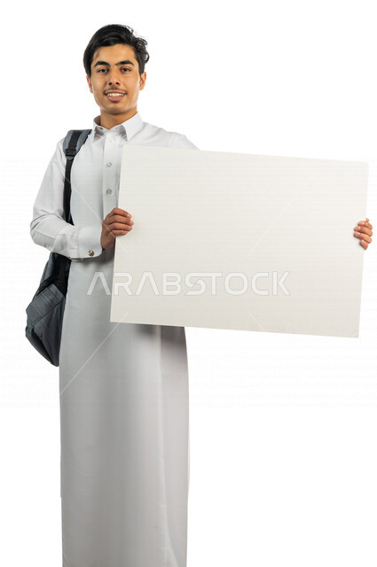 Portrait of a Saudi Arabian Gulf student holding an explanatory board in his hand, following daily lectures and lessons, teaching using explanatory boards and teaching aids, educational enrichment activities, education in the Kingdom of Saudi Arabia