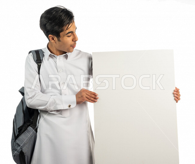 بورتريه لطالب عربي خليجي سعودي يحمل بيده لوحة توضيحية ،متابعة المحاضرات والدروس اليومية ،التعليم باستخدام لوحات توضيحية ووسائل تعليمية ،انشطة اثراء التعليم ، التعليم في المملكة العربية السعودية