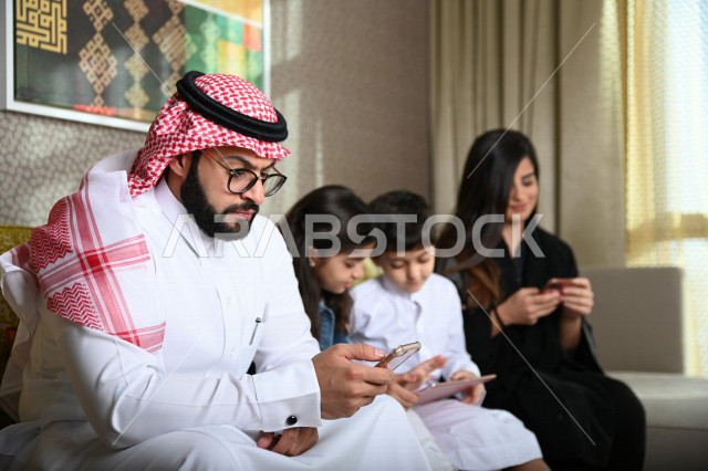 عائلة عربية خليجية سعودية تستخدم الاجهزة الالكترونية المحمولة ، التفاعل مع العالم الافتراضي ، التسوق الالكتروني ، مشاهدة الافلام والمسلسلات ، اجواء عائلية