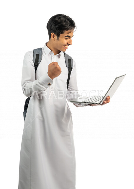 بورتريه لطالب جامعي عربي خليجي سعودي يحمل بيد الحاسوب المحمول ، ايماءات الوجه واليد تدل على الفوز والنجاح ، النجاح في الاختبار الجامعي الالكتروني ، حل الواجبات الجامعية الالكترونية  ،  التعليم الاكتروني ، خلفية بيضاء