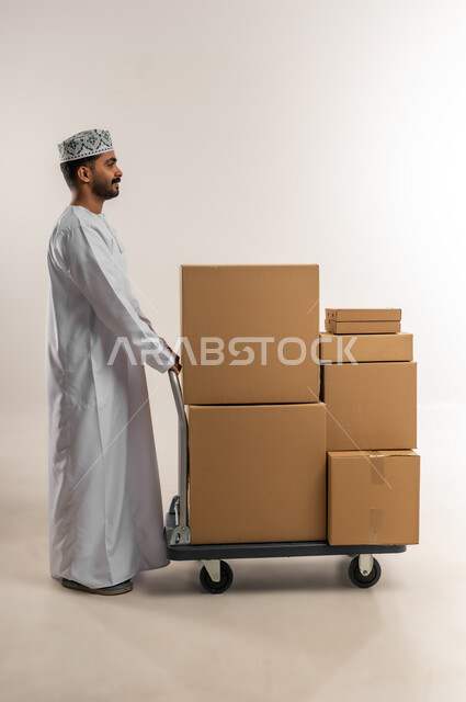 Online shopping and ordering, on-time and accurate delivery, high quality shipping and delivery service, portrait of a young Omani Gulf Arab man wearing a dishdasha and a kumquat holding a closed cardboard box, buying household needs, full body, white background